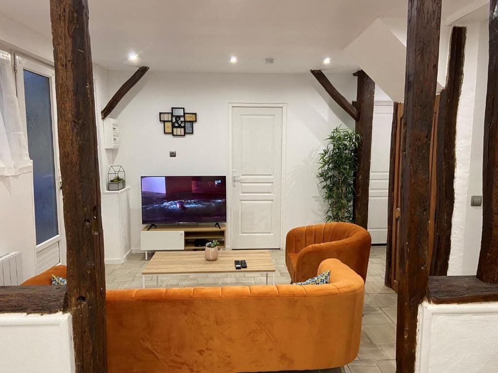 La Galerie, coin télévision entre poutres anciennes, meublé de tourisme à Tillé, aéroport de Beauvais