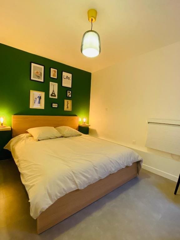 The Share House, chambre avec lit double et mur vert, hébergement partagé à Tillé, aéroport de Beauvais
